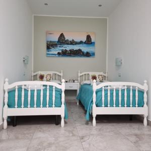 卡塔尼亚Al Punto Giusto的卧室内配有两张白色的床,墙上挂着一幅画