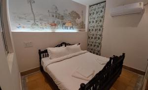 斋沙默尔Kiran Apartment的墙上有照片的一张小床