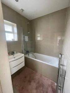 西德雷顿Lovely Detached house in lovely location的浴室配有白色浴缸和水槽
