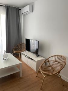 科尔多瓦Apartamento Colina B 19.的客厅配有2把椅子和平面电视