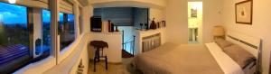 里米尼Family Dream Penthouse的白色的卧室设有床和大窗户