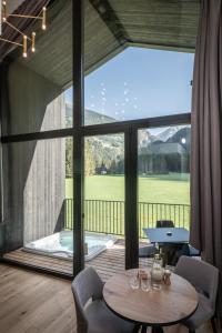 坎波图雷斯Såndgøld Alpine Glamping的客房设有桌子和带浴缸的大窗户。