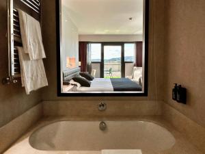 奥维罗巴拉加里斯URH温泉禅酒店的一间带大镜子和浴缸的浴室