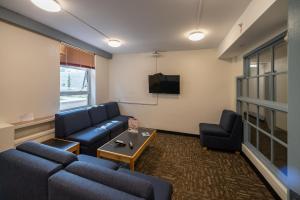 温哥华瓦尼埃学生宿舍帕西斯比特旅馆的客厅配有蓝色的沙发和电视