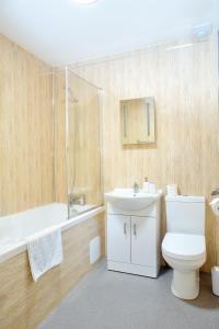 罗切斯特Trivelles Rochester Hotel的浴室配有卫生间、浴缸和水槽。