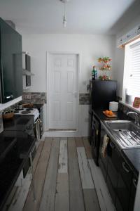 锡厄姆Sara’s Apartment的厨房设有白色的门,铺有木地板