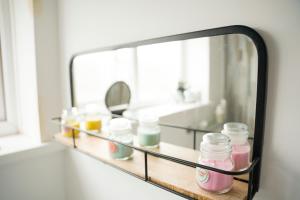 锡厄姆Sara’s Apartment的浴室内架上装有罐子的镜子