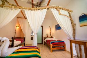 普拉纳维瑙维闹海滩度假酒店及冲浪营的一间卧室配有两张床和窗帘