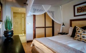 卡萨内Chobe Marina Lodge的一间卧室配有一张大床和仙人掌