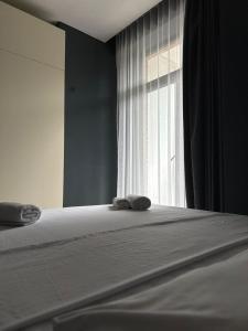第比利斯A-Y Apartments P A4的窗户前的一张床上有两条毛巾