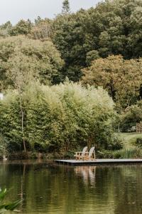 普莱贝-克里斯特Gîtes du Bulz, en pleine forêt proche de la mer的两个长椅坐在湖边的码头上