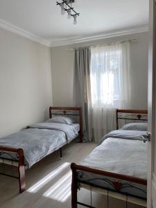 久姆里Lidiani Guest House的一间卧室设有两张床和窗户。