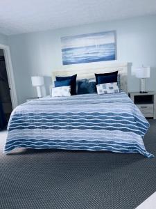 默特尔比奇The Chelsea House Villas, Gorgeous condo-OceanView-Jacuzzi的一张带蓝白条纹毯子的大床