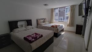 阿雷基帕Departamento amplio y bonito en Arequipa的酒店客房设有两张床和窗户。