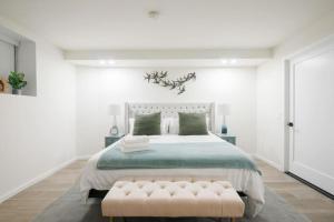纽约Luxury 2BR Duplex 5min to Central Park的白色卧室设有一张大床和长凳