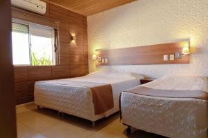 里奥格兰德Pousada Costa Doce的一间卧室设有两张床和窗户。