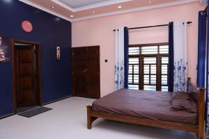 贾夫纳Hajiz Palace的一间卧室配有一张蓝色墙壁的床和一扇窗户