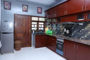 贾夫纳Hajiz Palace的厨房配有木制橱柜和炉灶烤箱。