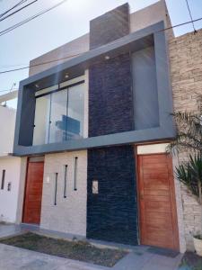 皮斯科Airbnb Paracas Inn的一座带大窗户和木门的房子