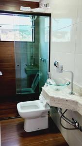 波苏斯-迪卡尔达斯Casa Única e Moderna Centro的一间带卫生间和玻璃淋浴间的浴室