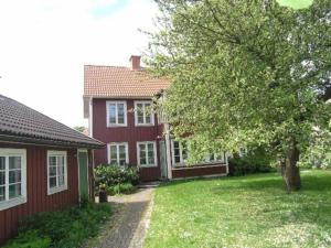 卡尔马Central villa med extra allt. Pool, Bastu, Utekök的前面有一棵树的红色房子