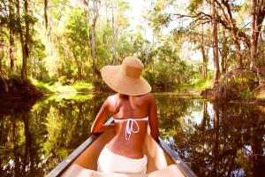 奥兰多奥兰多格兰德湖丽兹卡尔顿酒店的河上划独木舟的戴帽子的妇女