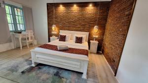 丹不拉Kandalama Lodge的卧室配有白色的床和砖墙