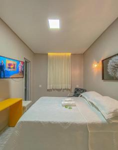 福塔莱萨Pousada atalaia ll的卧室设有一张白色大床和一扇窗户。