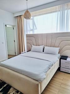 内罗毕Avana的卧室设有一张大床,卧室设有大窗户