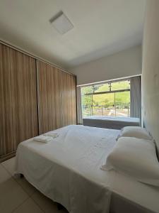 卡皮托利乌Suites Silva的卧室配有一张大白色床和窗户