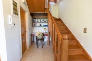 斯塔里斯Astali Villa的走廊上设有楼梯,通往房子内的书桌