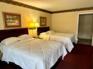 PrincetonThe Stratton Inn的配有白色床单的酒店客房内的两张床