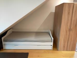 汉堡Zimmer 31qm inkl. Duschbad的楼梯下的一张带木柜的床