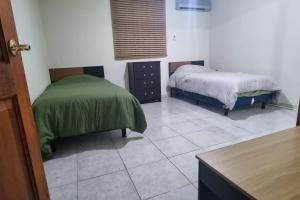 坦皮科Departamento Planta Baja para 6的一间带两张床的卧室,铺有瓷砖地板。