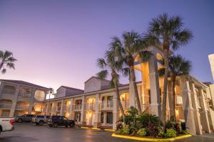 圣奥古斯丁海滩Best Western Seaside Inn的停车场内棕榈树的大型建筑
