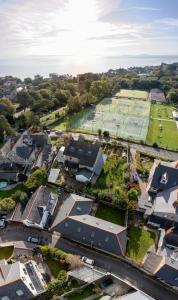 卡迪夫Seaview Cottage的享有村庄的空中景致,设有网球场