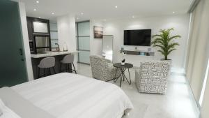 圣胡安Ocean Front Coral Luxury Apartment的白色卧室设有白色的床和厨房