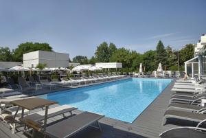 蒂米什瓦拉欧陆酒店的一座带躺椅和桌子的游泳池