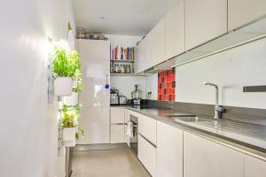 圣芒代Bright two-bedroom in the heart of Saint-Mandé - Welkeys的厨房配有白色橱柜和盆栽植物