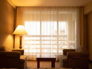 艾哈迈达巴德Radisson Blu Hotel Ahmedabad的客厅设有窗户、两把椅子和一张桌子