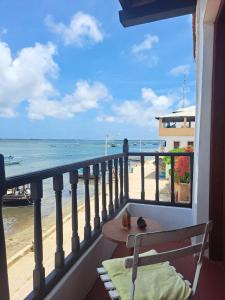 拉穆Pwani House - Lamu Seafront的阳台配有桌子,享有海滩美景