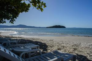 弗洛里亚诺波利斯Mighil Hotel & Eventos的海滩上的一组椅子,与大海相连