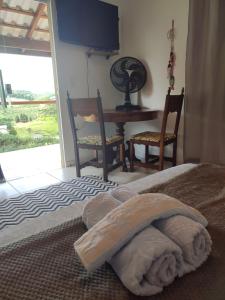 多明戈斯马丁斯Pousada Canto Alegre Domingos Martins ES的卧室配有一张床和一张桌子及椅子