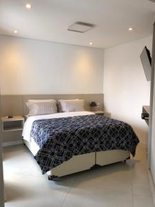 圣保罗皇家伊比拉普埃拉公园公寓的一间卧室配有床和2个床头柜