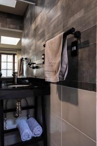 拉巴斯BB&B Hostel的浴室设有水槽,墙上有毛巾