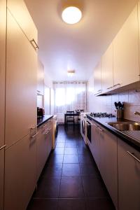 日内瓦hyper centre carouge QDC的一间大厨房,配有白色的橱柜和水槽