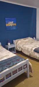 拉库布蕾HOTEL PARAISO的蓝色墙壁客房的两张床