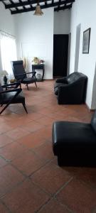 拉库布蕾HOTEL PARAISO的客房铺有瓷砖地板,配有沙发和椅子。