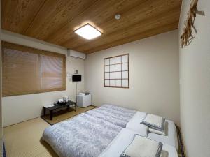 成田Karin doo Hotel的一间卧室设有一张大床和木制天花板