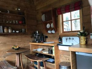 阿卡罗阿Kanuka Retreat的厨房设有木墙和带凳子的台面。